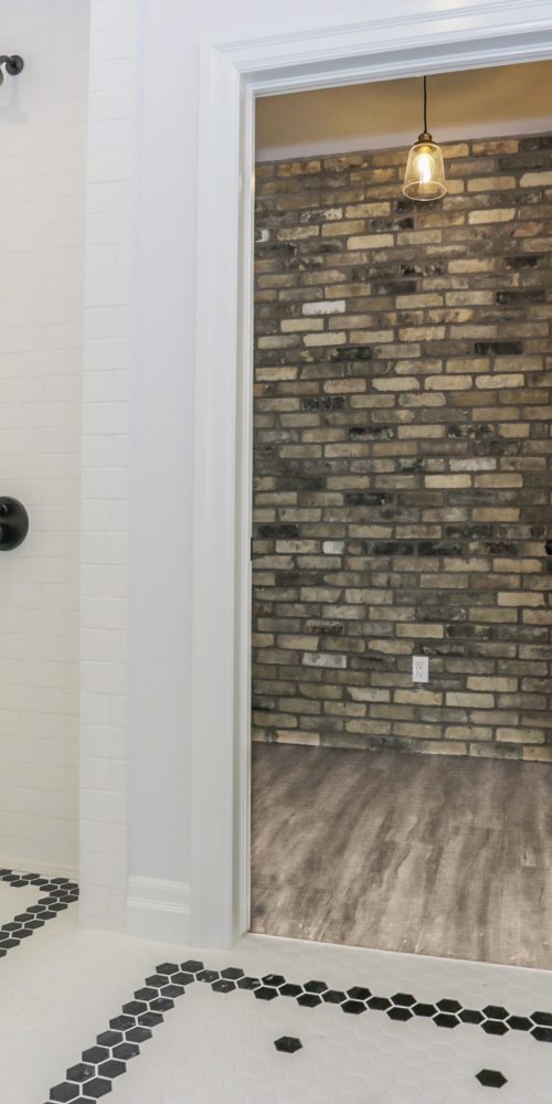 Bathroom with black and white tiles and a non-enclosure shower